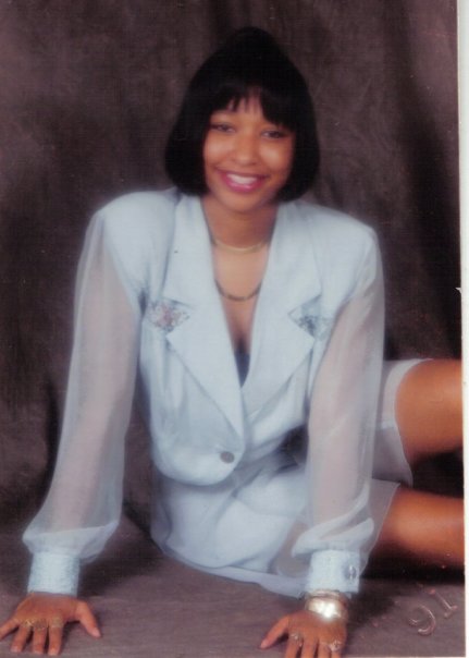 Photo taken, possibly in the early 90s of a beautiful woman in a blue jumpsuit